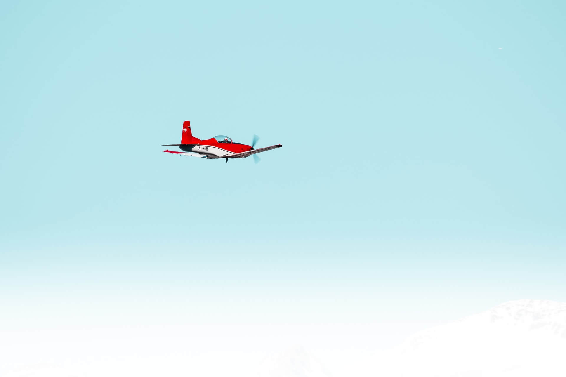 Red plane flying in clear skies